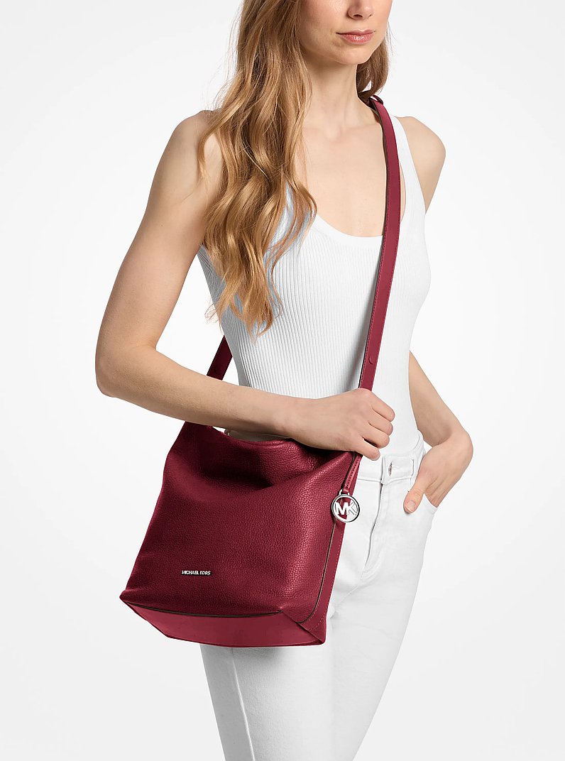 Roey Medium Pebbled Leather Bucket Messenger Bag in MAROON | Michael Kors