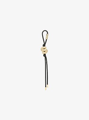 Colgante de inicial para bolso con cord&oacute;n en tono dorado y motas